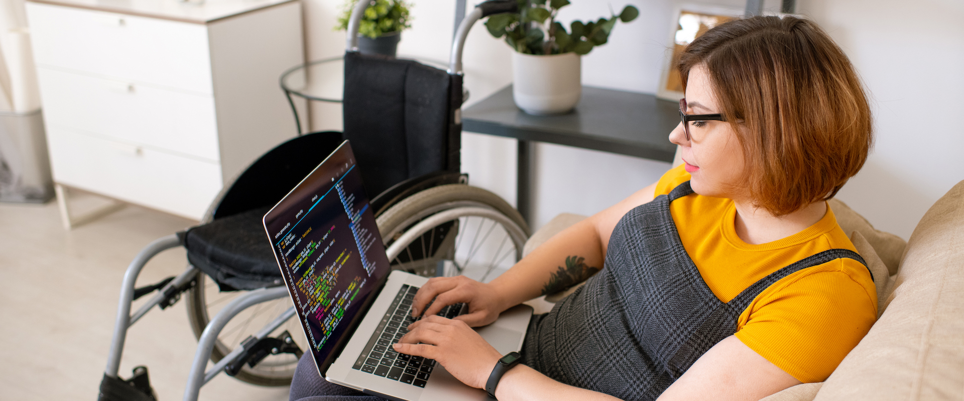 Eine Frau im Rollstuhl arbeitet am Computer